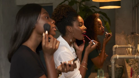 Three friends applying makeup at ladies' room