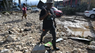 A man walks with a shovel in hand over rubble on Main Street in Santa Cruz, St. Elizabeth, Jamaica.