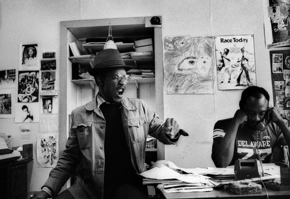 Adrian​ Boot​, Linton-Kwesi-Johnson​, and Darkus-Howe​ at​ the​ Race​ Today​ office​ on​ Railton​ Road​, Brixton​, 1979​. Image: Adrian​ Boot​, urbanimage.tv